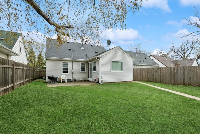 rear view of house featuring a lawn, roof with shingles, a fenced backyard, and a patio area
