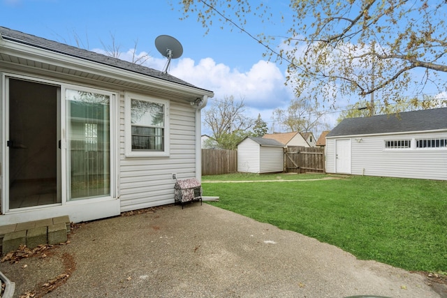 view of yard with a storage shed, an outbuilding, a fenced backyard, and a patio area