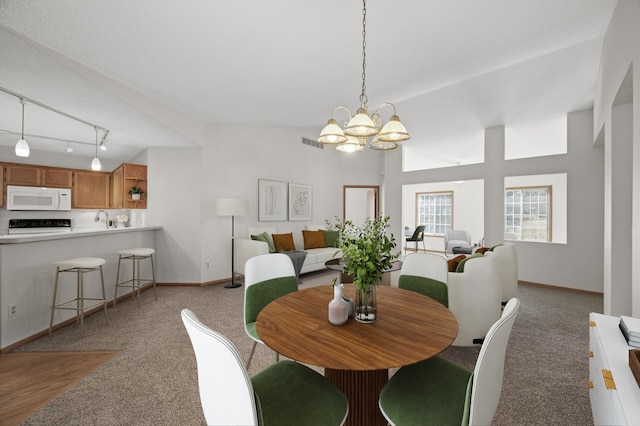 8569 Telford Ln N, Brooklyn Park, MN 55443 - dining space featuring a chandelier, light colored carpet, and baseboards