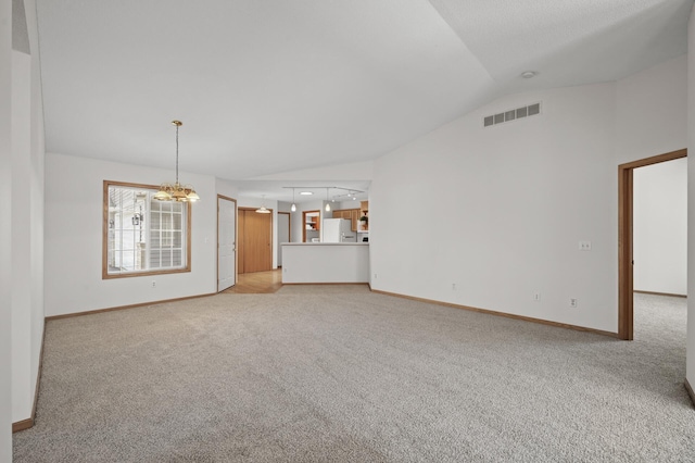 8569 Telford Ln N, Brooklyn Park, MN 55443 - unfurnished living room featuring lofted ceiling, light carpet, baseboards, and a chandelier