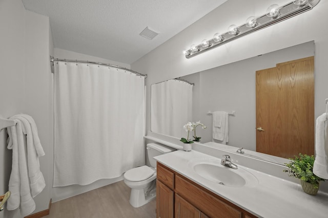 8569 Telford Ln N, Brooklyn Park, MN 55443 - bathroom featuring vanity, toilet, wood finished floors, shower / tub combo with curtain, and a textured ceiling