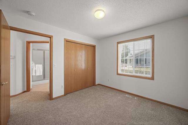 8569 Telford Ln N, Brooklyn Park, MN 55443 - unfurnished bedroom with carpet floors, a closet, a textured ceiling, and baseboards