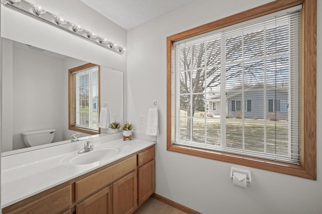 8569 Telford Ln N, Brooklyn Park, MN 55443 - bathroom featuring toilet, vanity, and baseboards