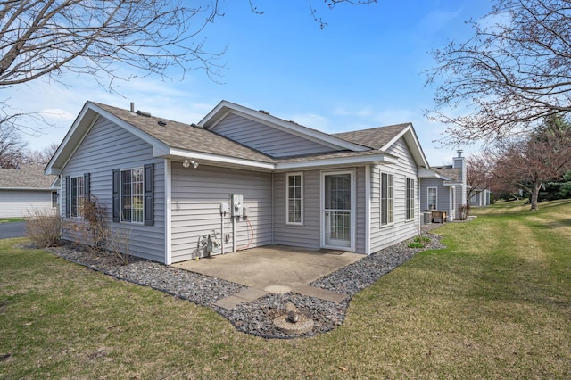 8569 Telford Ln N, Brooklyn Park, MN 55443 - back of property featuring a patio, a shingled roof, and a lawn