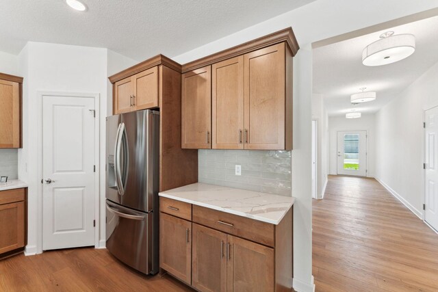 17729 Everest Ave, Lakeville, MN 55044 - kitchen featuring stainless steel fridge, wood finished floors, decorative backsplash, and brown cabinetry