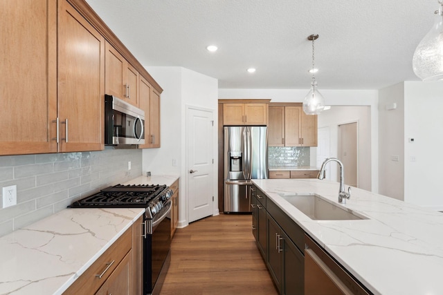 17729 Everest Ave, Lakeville, MN 55044 - kitchen featuring stainless steel appliances, a sink, wood finished floors, tasteful backsplash, and pendant lighting