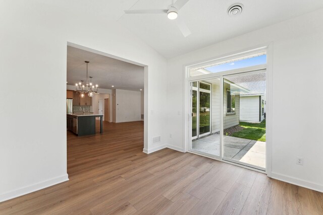 17729 Everest Ave, Lakeville, MN 55044 - unfurnished room featuring a ceiling fan, lofted ceiling, a chandelier, wood finished floors, and baseboards
