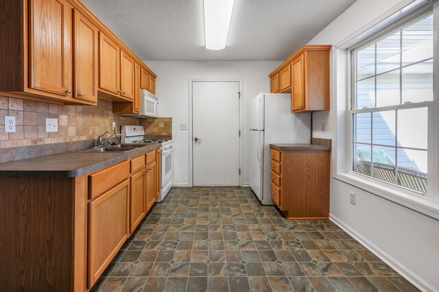 1065 Blackbird Trl SW Unit 8, Hutchinson, MN 55350 - kitchen with white appliances, a sink, dark countertops, a textured ceiling, and decorative backsplash