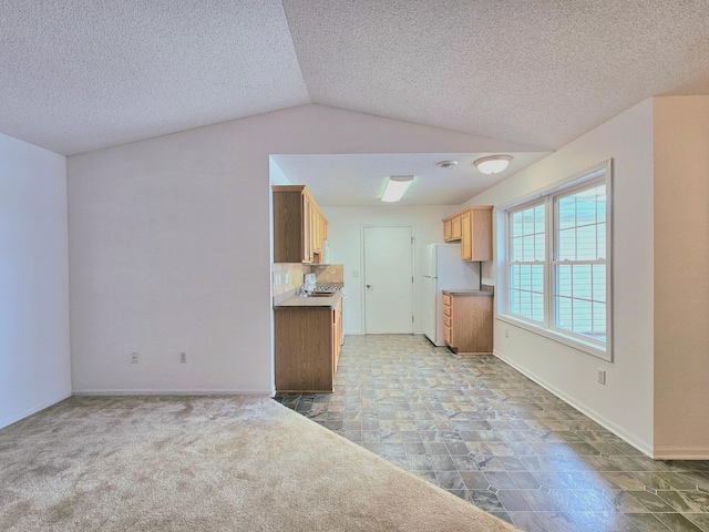1065 Blackbird Trl SW Unit 8, Hutchinson, MN 55350 - kitchen featuring freestanding refrigerator, vaulted ceiling, baseboards, a textured ceiling, and open floor plan