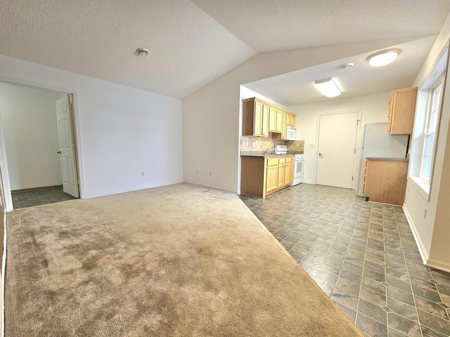 1065 Blackbird Trl SW Unit 8, Hutchinson, MN 55350 - kitchen featuring white appliances, vaulted ceiling, open floor plan, tasteful backsplash, and a textured ceiling