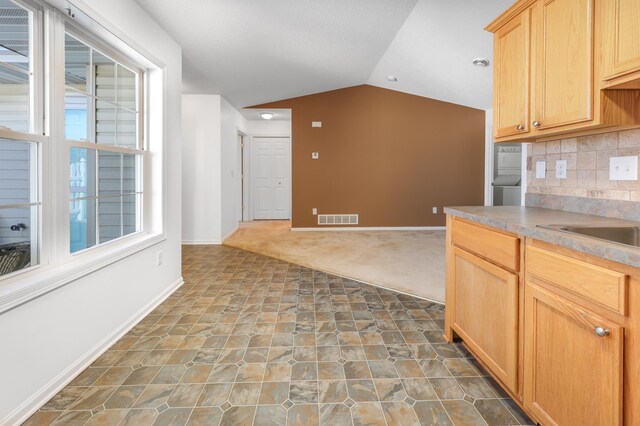 1065 Blackbird Trl SW Unit 8, Hutchinson, MN 55350 - kitchen with lofted ceiling, baseboards, tasteful backsplash, stone finish floors, and light brown cabinets