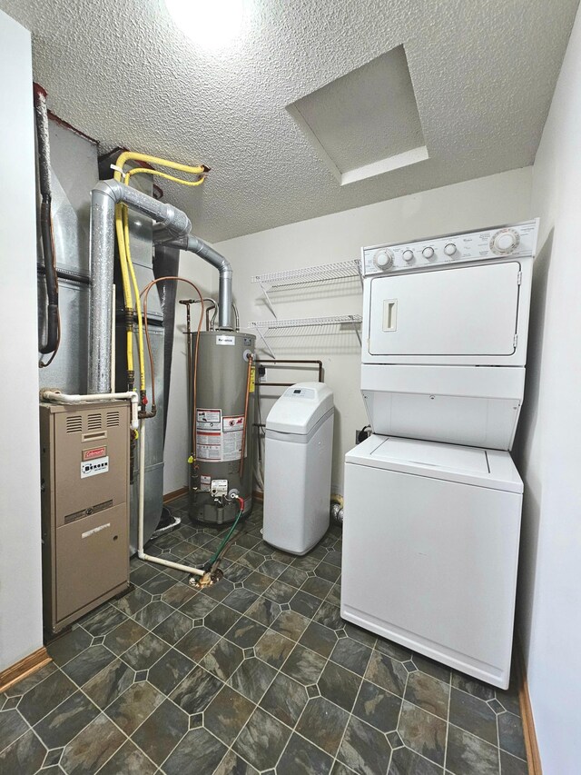 1065 Blackbird Trl SW Unit 8, Hutchinson, MN 55350 - clothes washing area featuring water heater, stacked washing machine and dryer, a textured ceiling, and attic access