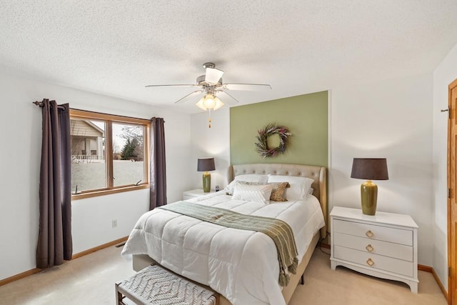 bedroom featuring baseboards, ceiling fan, light colored carpet, and a textured ceiling