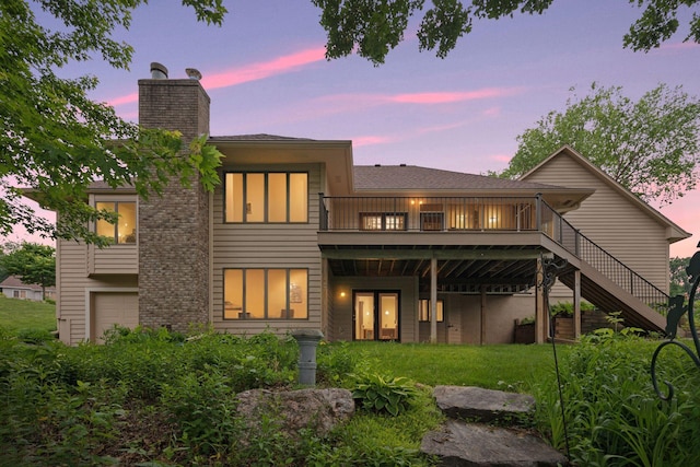 11765 177th St W, Lakeville, MN 55044 - back of property at dusk featuring a chimney, a deck, an attached garage, stairway, and a yard