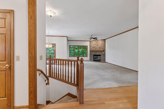 11765 177th St W, Lakeville, MN 55044 - carpeted living room featuring a ceiling fan, a brick fireplace, a chandelier, wood finished floors, and ornamental molding