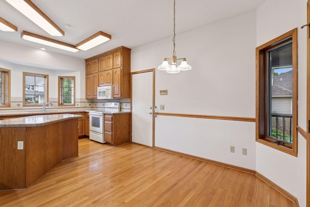 11765 177th St W, Lakeville, MN 55044 - kitchen featuring white appliances, brown cabinetry, light wood-style floors, and a chandelier