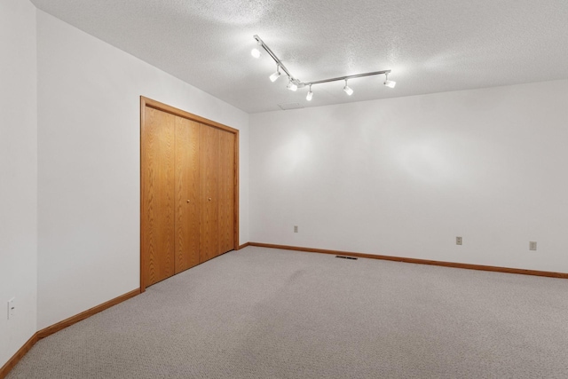 11765 177th St W, Lakeville, MN 55044 - unfurnished bedroom featuring carpet flooring, a closet, a textured ceiling, and track lighting