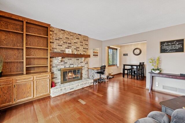 living room with wood finished floors and a fireplace