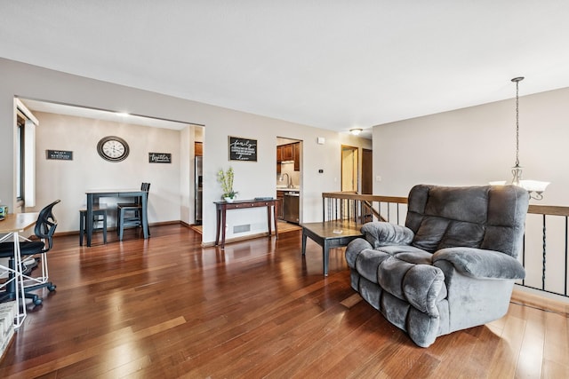 living area featuring wood-type flooring and a notable chandelier