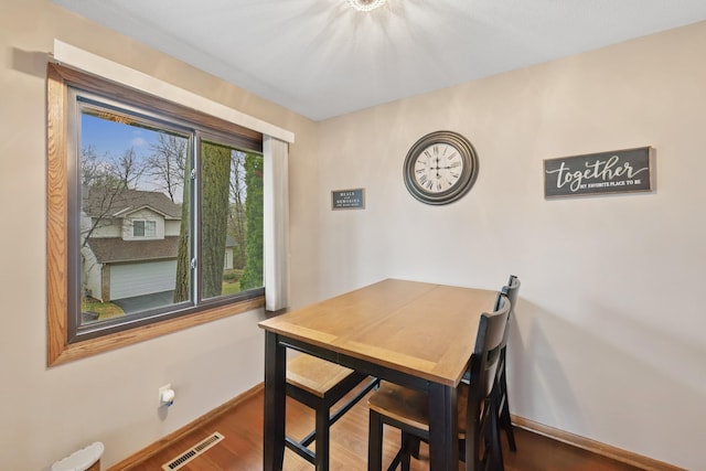 dining room with baseboards, wood finished floors, and visible vents