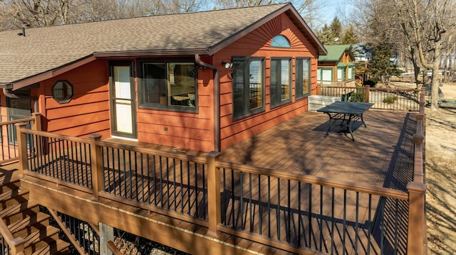 view of property exterior with a shingled roof and a deck