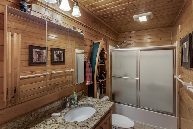 full bath with wood walls, toilet, vanity, shower / bath combination with glass door, and wooden ceiling