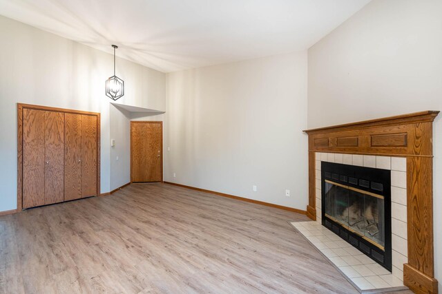 130 Teton Ln Unit 8, Mankato, MN 56001 - unfurnished living room with a tile fireplace, light wood finished floors, and vaulted ceiling