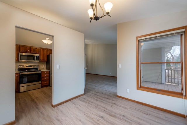 130 Teton Ln Unit 8, Mankato, MN 56001 - kitchen featuring stainless steel appliances, light wood-style flooring, brown cabinets, a chandelier, and light countertops