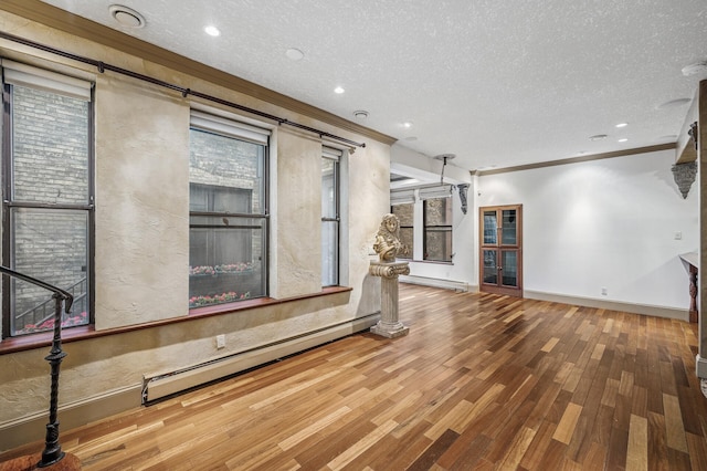 1801 Elliot Ave Unit 4And 6, Minneapolis, MN 55404 - unfurnished living room with wood finished floors, crown molding, a textured ceiling, baseboards, and baseboard heating