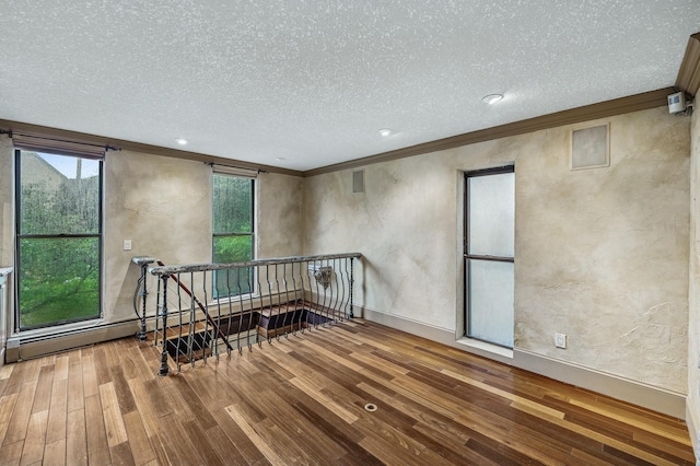 1801 Elliot Ave Unit 4And 6, Minneapolis, MN 55404 - spare room with crown molding, wood finished floors, a textured ceiling, a textured wall, and baseboards