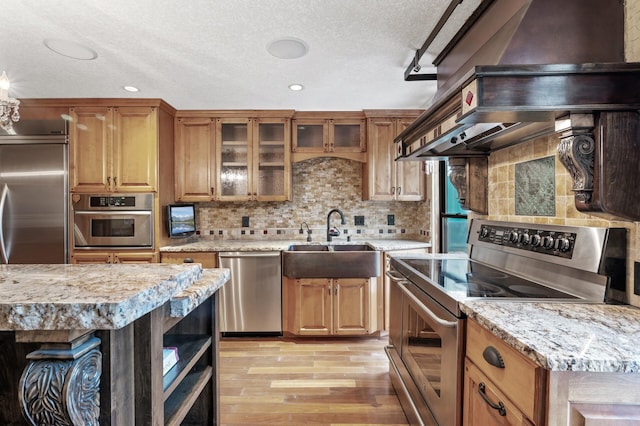 1801 Elliot Ave Unit 4And 6, Minneapolis, MN 55404 - kitchen with appliances with stainless steel finishes, a sink, light wood-style floors, a textured ceiling, and backsplash