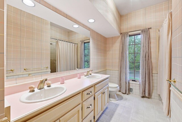 461 Peavey Ln, Wayzata, MN 55391 - bathroom with tile walls, tile patterned floors, double vanity, recessed lighting, and a shower with curtain