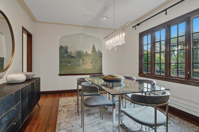 dining space featuring dark wood-style flooring, baseboards, and crown molding