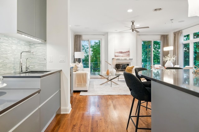 kitchen with a sink, decorative backsplash, healthy amount of natural light, ceiling fan, and recessed lighting