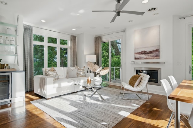 living room featuring wine cooler, a dry bar, wood finished floors, a ceiling fan, and recessed lighting