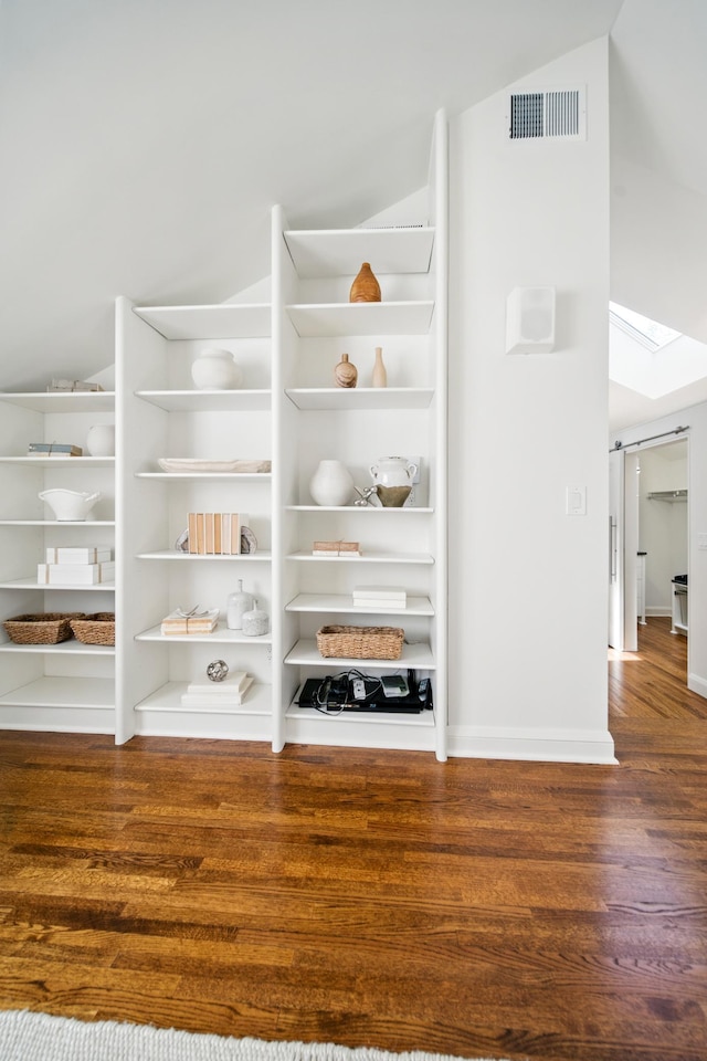 detailed view of wood finished floors and a skylight