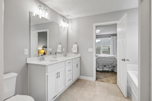 ensuite bathroom featuring toilet, a sink, and ensuite bath