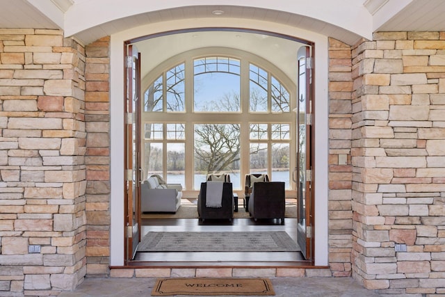 view of exterior entry featuring brick siding and a water view