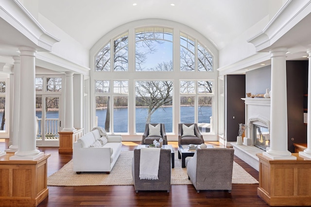 living room with ornate columns, vaulted ceiling, and a healthy amount of sunlight