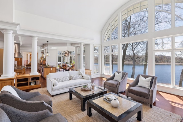 sunroom featuring an inviting chandelier, a sink, and a water view