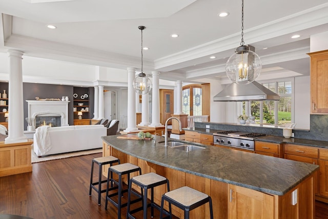 kitchen with a sink, recessed lighting, ornate columns, and dark wood finished floors