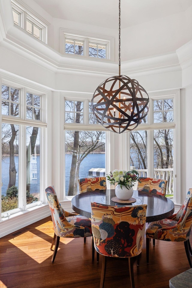 sunroom / solarium with a water view, a chandelier, and plenty of natural light