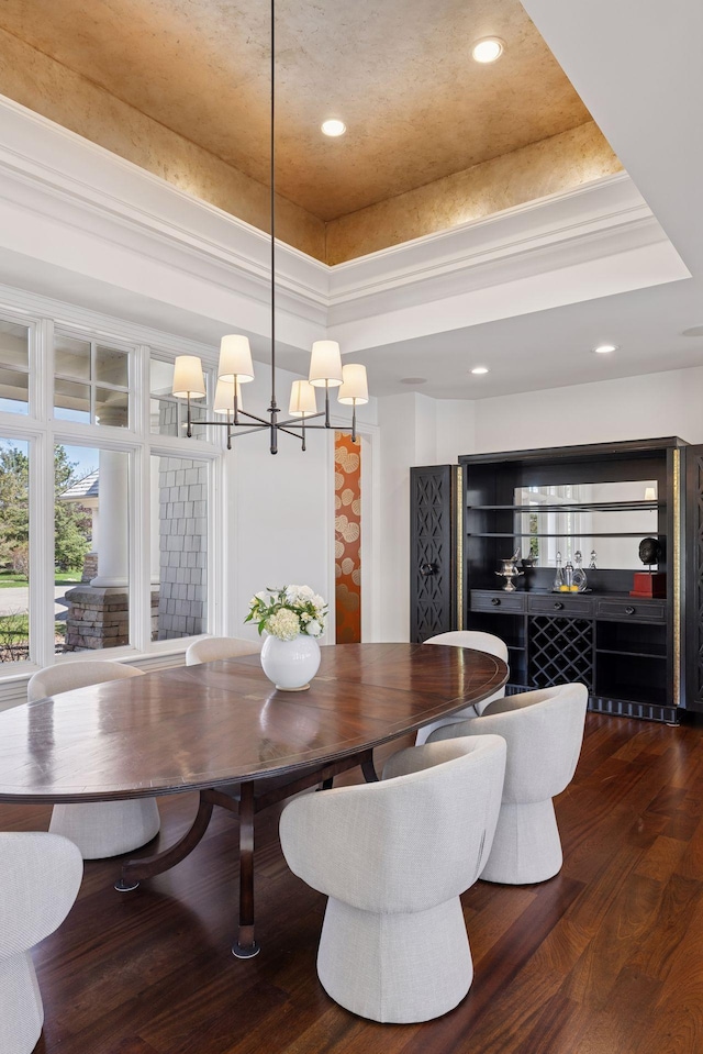 dining space featuring an inviting chandelier, a tray ceiling, recessed lighting, and wood finished floors