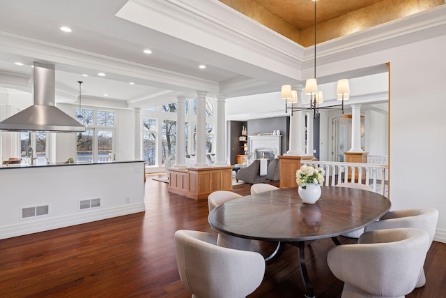 dining space with an inviting chandelier, baseboards, dark wood-type flooring, ornate columns, and visible vents