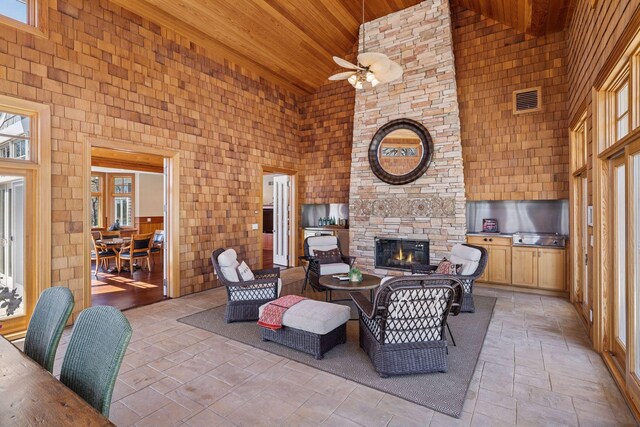 view of patio / terrace featuring visible vents, ceiling fan, and a fireplace