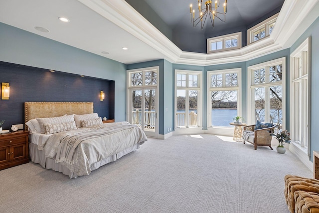 carpeted bedroom featuring a high ceiling, an inviting chandelier, recessed lighting, baseboards, and a water view