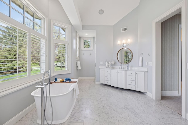 bathroom with baseboards, plenty of natural light, and marble finish floor