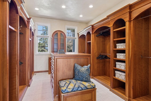 walk in closet featuring light colored carpet