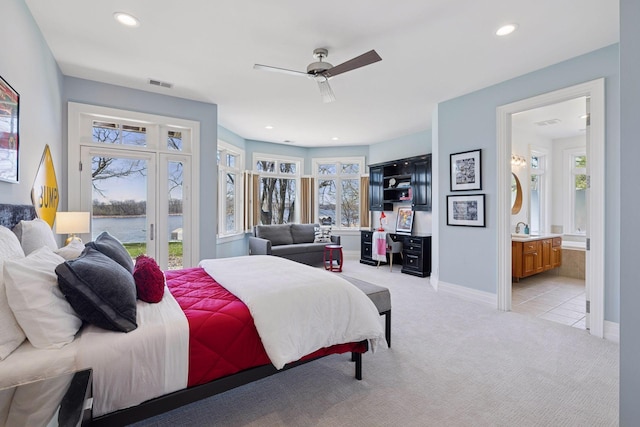 bedroom featuring access to outside, light carpet, a sink, a water view, and visible vents