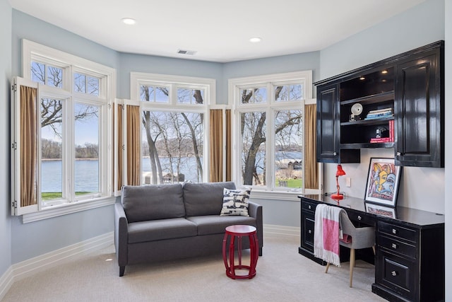home office featuring baseboards, light carpet, a water view, and visible vents